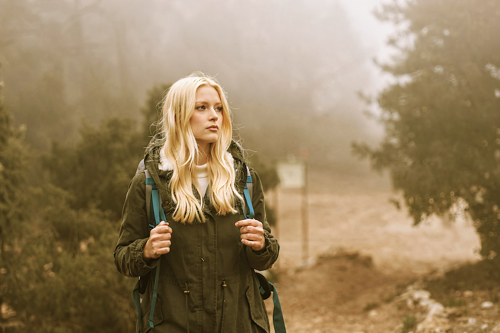 Happy woman hiker in a misty forest