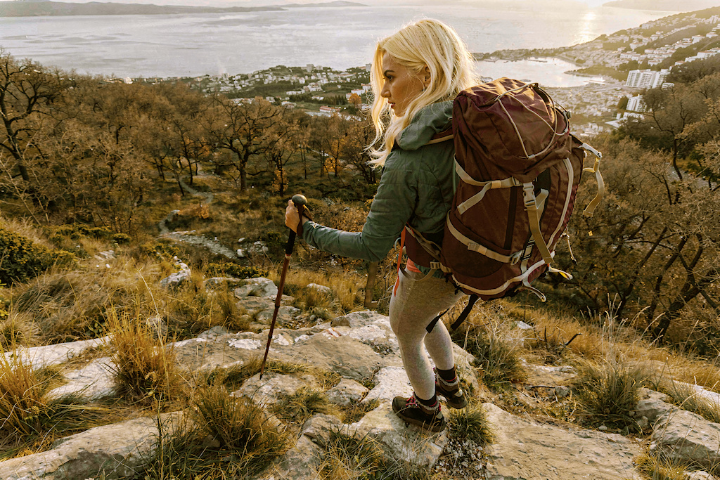 Hiker with a map looking out over a mountain range
